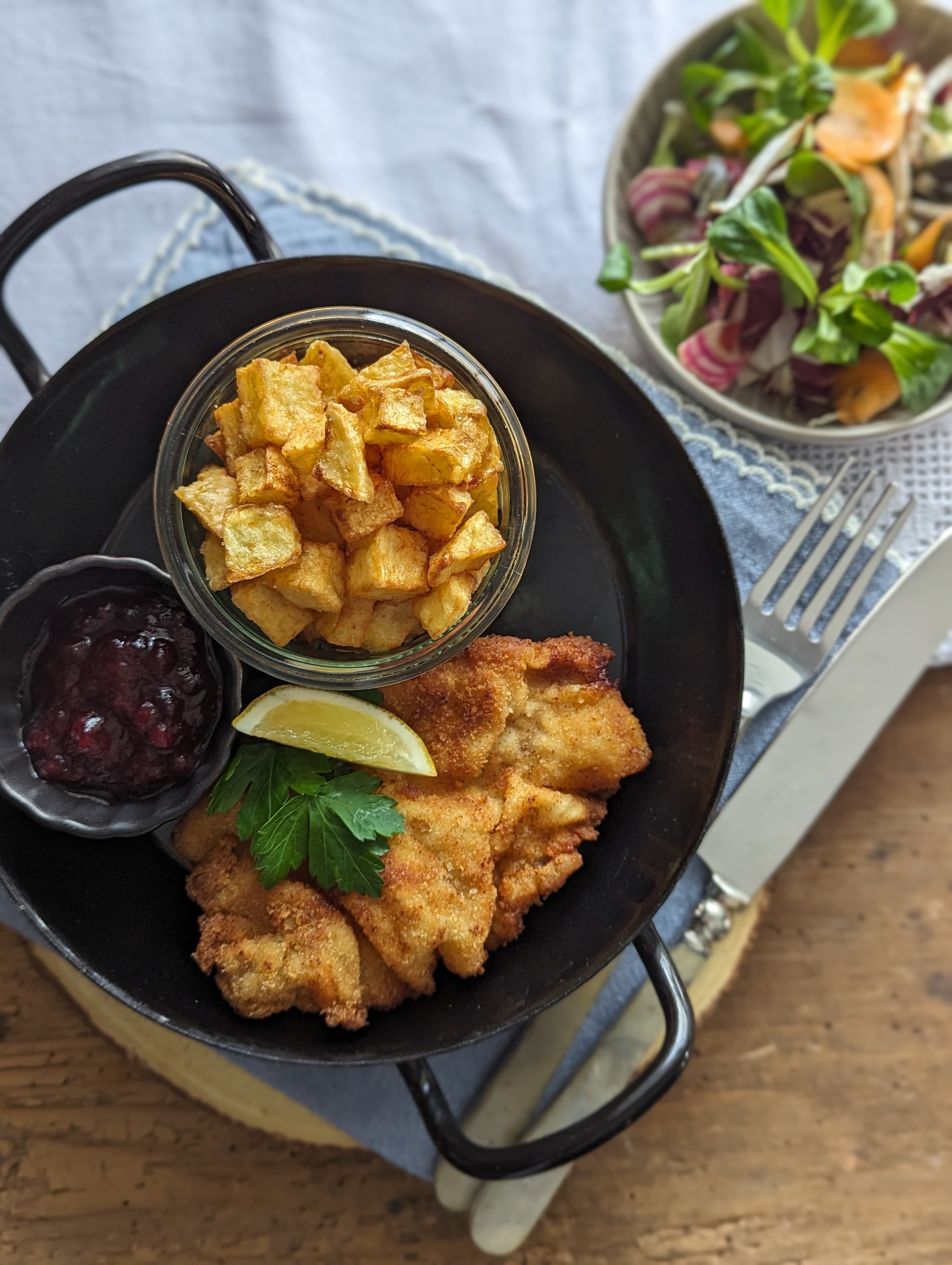 Schnitzel mit Pommeswürfel und Salat bei Salzburg schmeckt