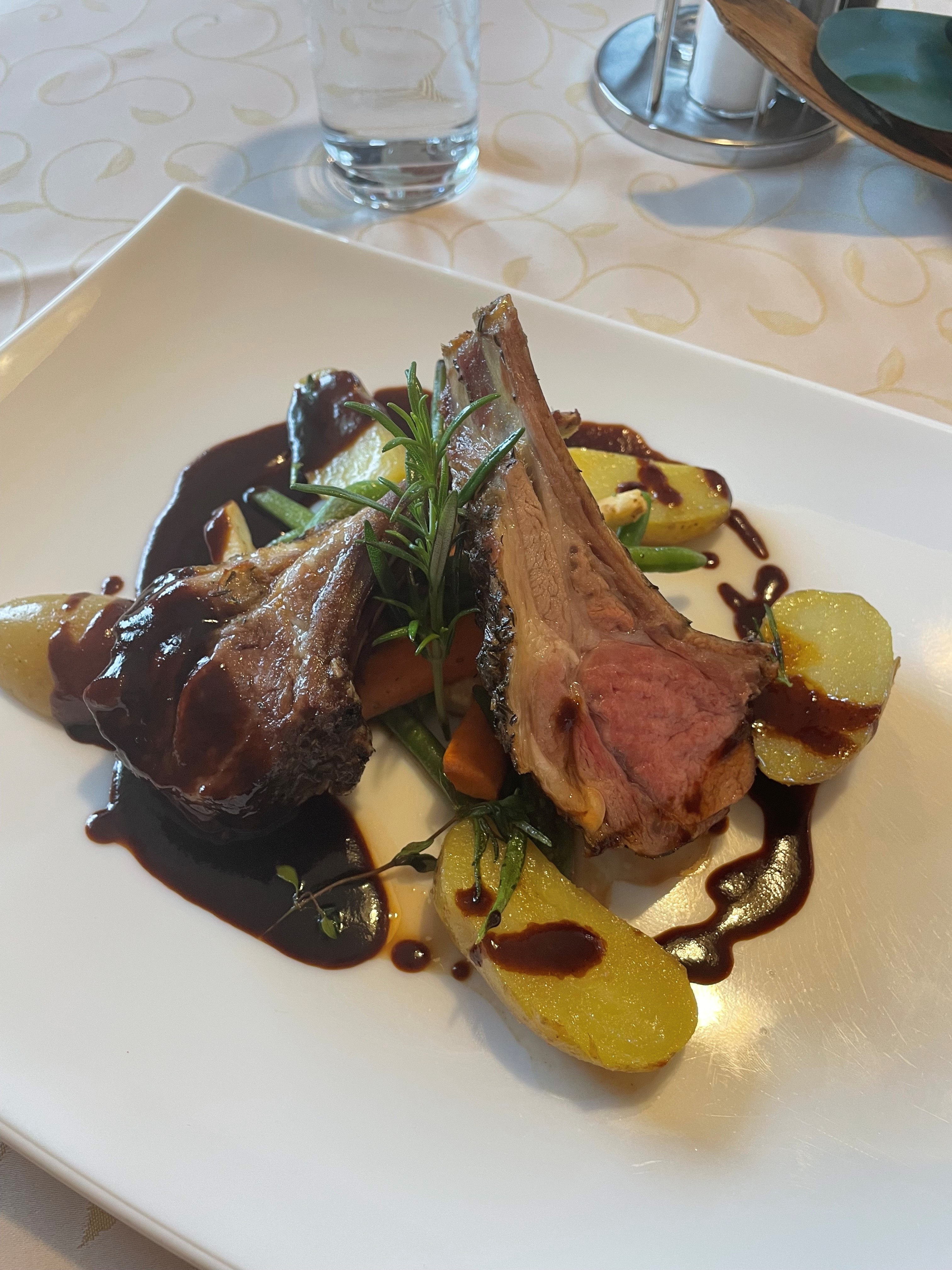 Rosa gebratene Lammkrone mit Rosmarinkartoffeln und Gemüse bei Salzburg schmeckt