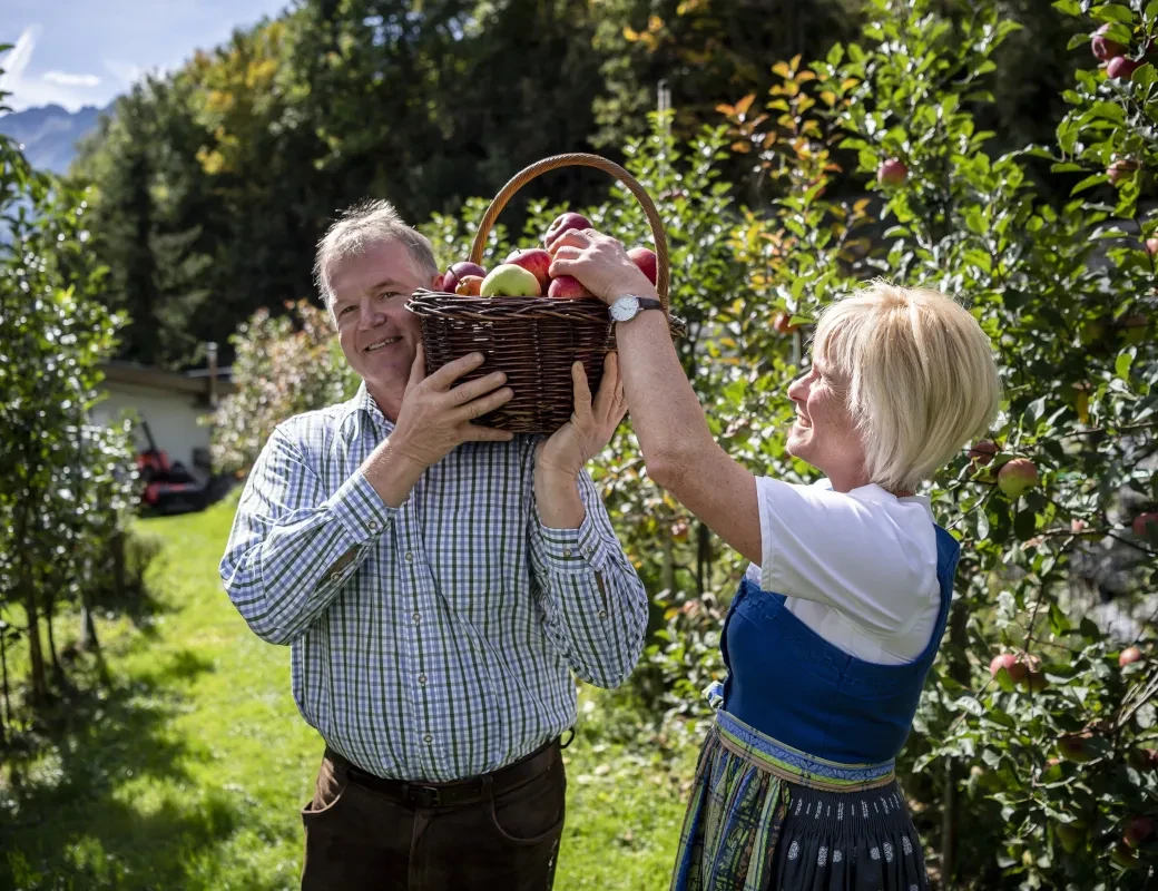 Obstbau Leitner_Karoline und Norbert Leitner mit einem Korb mit Äpfeln
