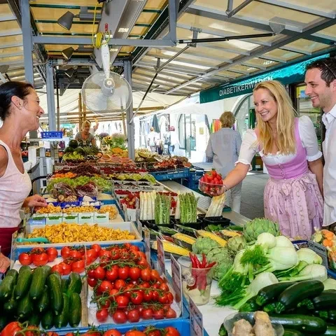 Marktstand mit Besuchern Grünmarkt Salzburg