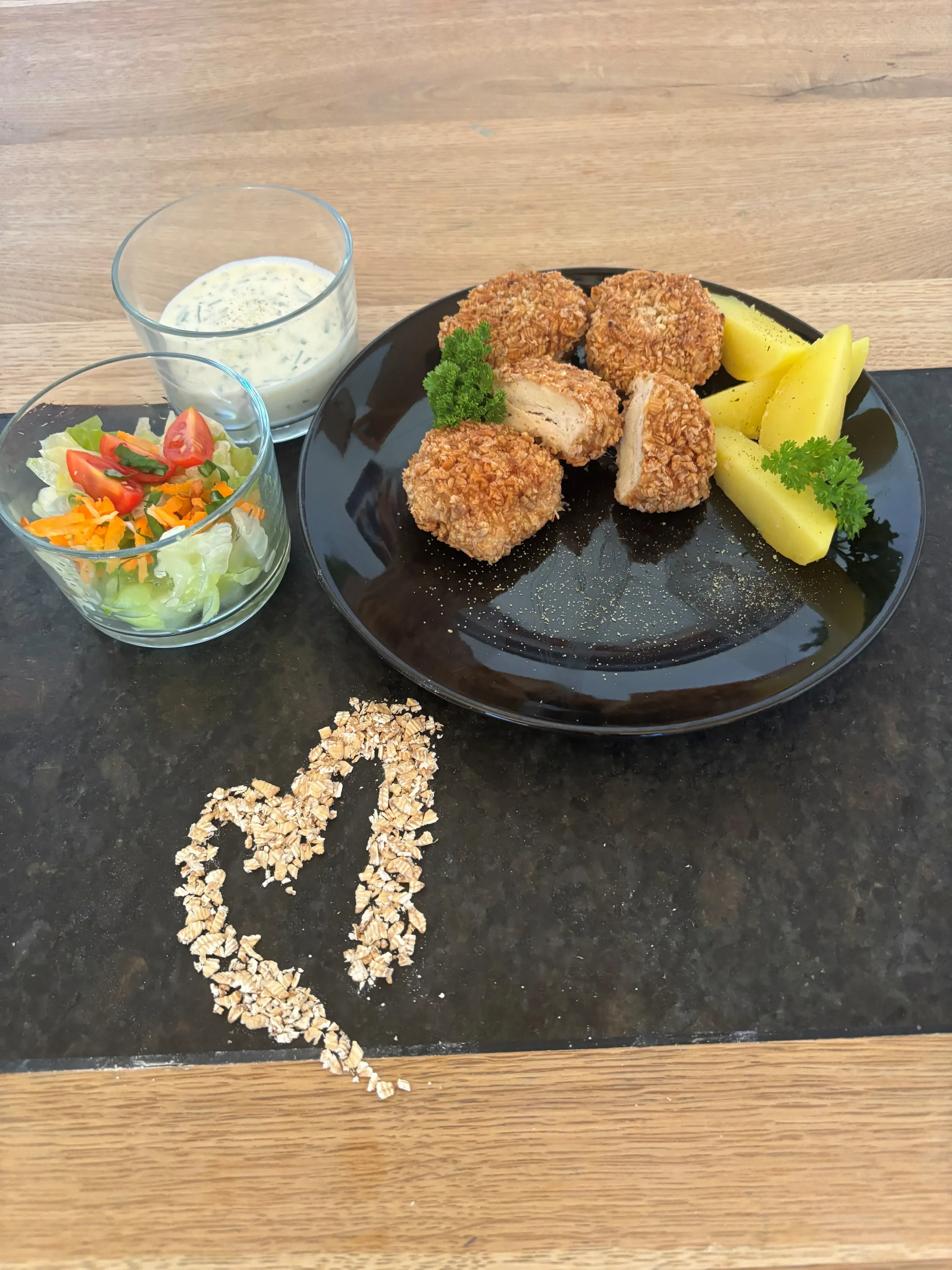 Hühnernuggets mit Kartoffeln auf Teller und Salat