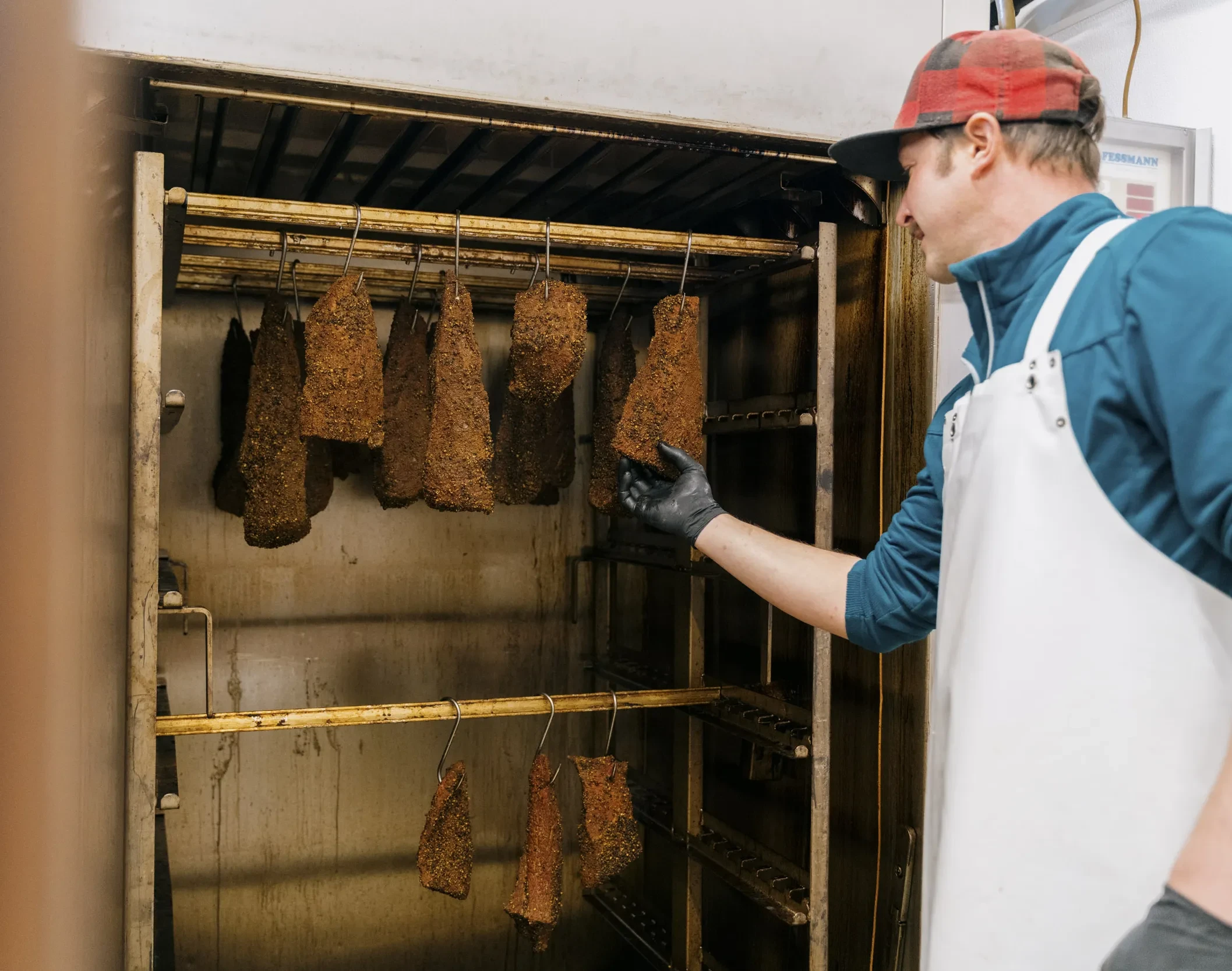 Andreas Teufl füttert die Pastrami Selch.