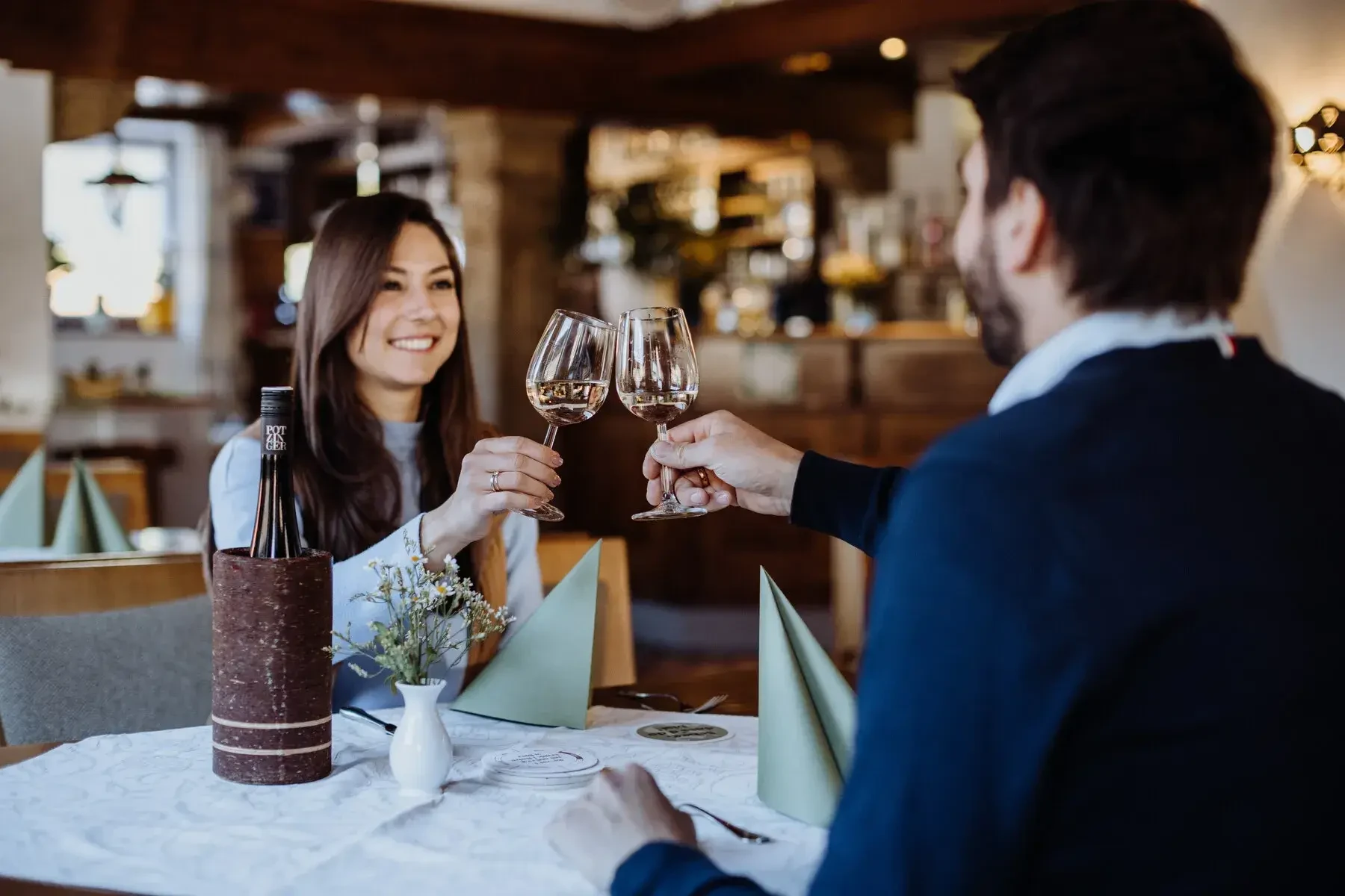 Paar im Restaurant mit Weingläsern anstoßen