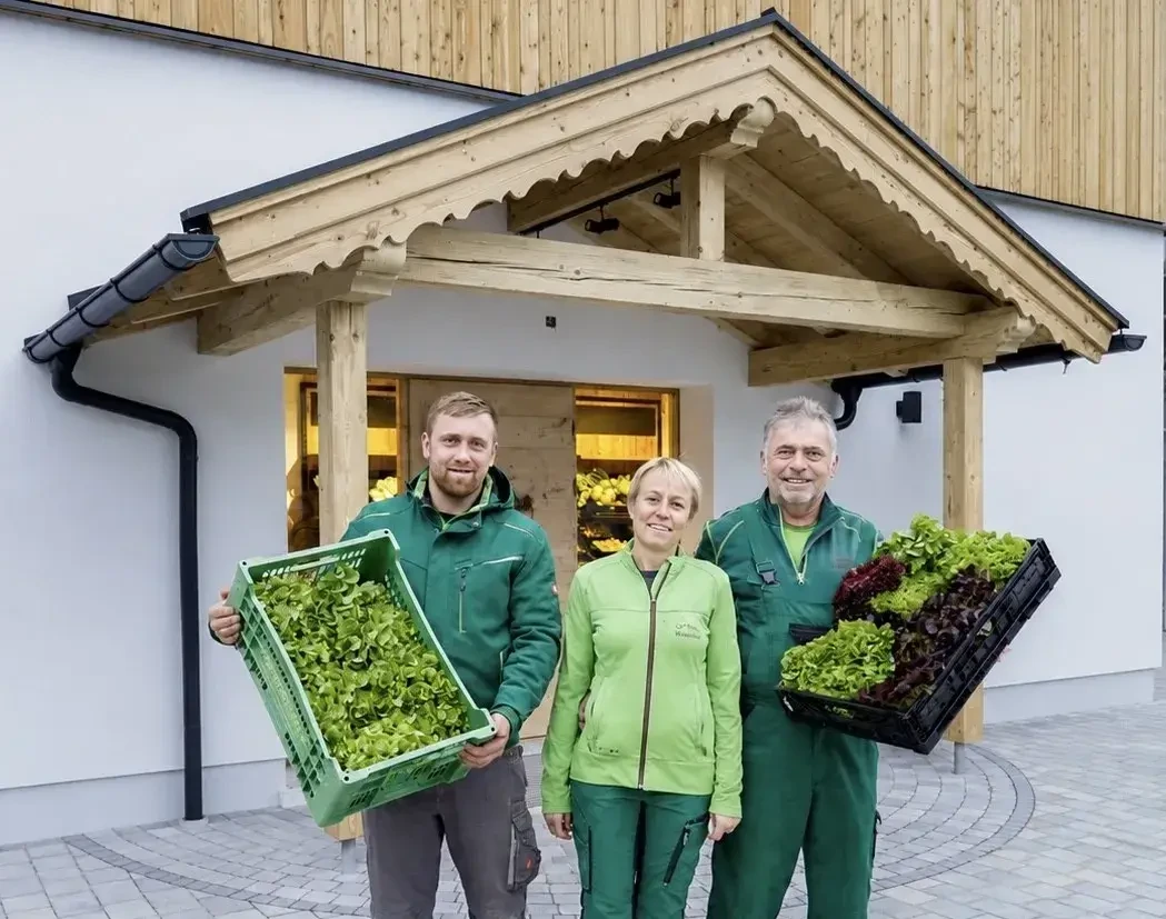 Winklhofer Familie vor Hofladen mit Kisten voller Salat
